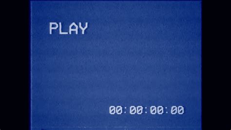 An old bad VHS tape playing. Blue screen with PLAY text and timecode. A ...