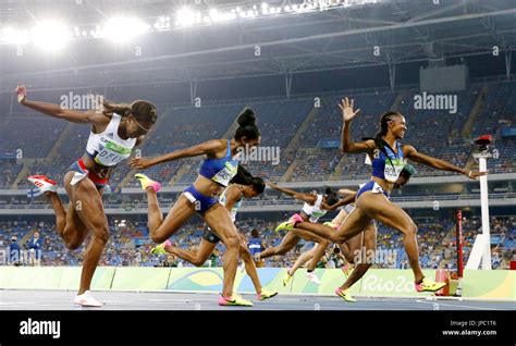 Brianna Rollins (far R) of the United States crosses the finish line to ...