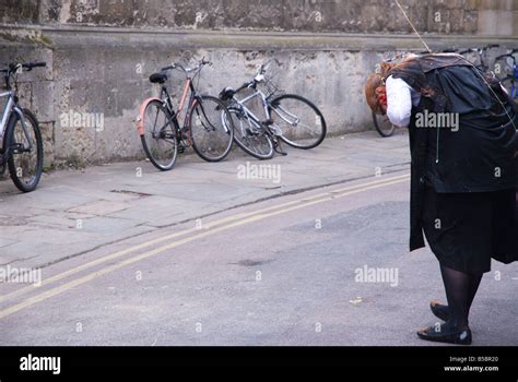 Oxford University student in subfusc covered in food and holding the string of a celebratory ...