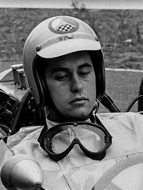 a man sitting in a race car with goggles on