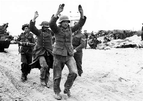 German troops captured by British forces on D-Day are seen on Sword Beach (June 6, 1944). Via ...