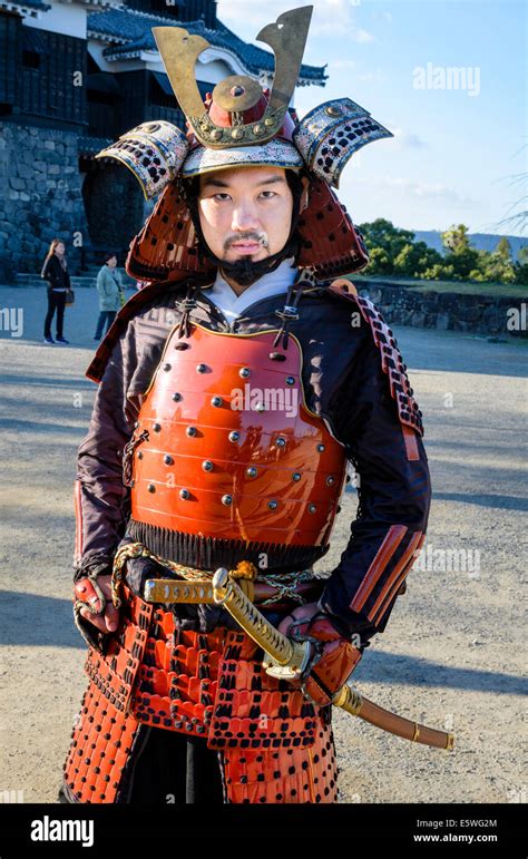 Japanese man wearing traditional samurai armour / armor, including helmet and swords Stock Photo ...