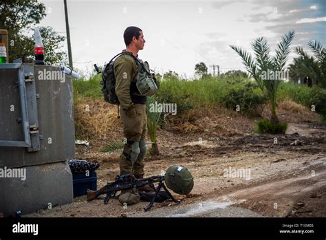 26 March 2019, Israel, Nahal Oz: An Israeli soldier stands next to his machine gun near the ...