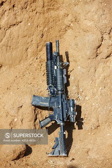 M4 carbine, fitted with an M203 40mm grenade launcher, live loaded, at ...