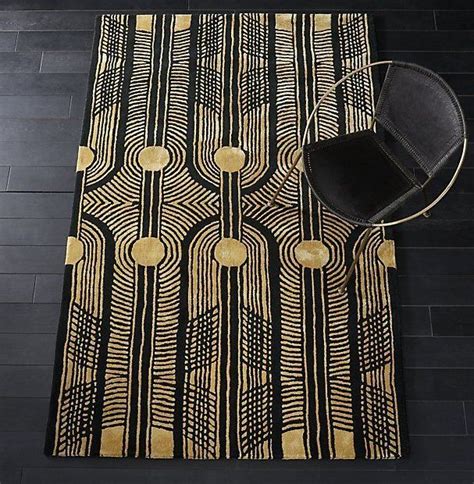 deco-inspired. Woven from thick wool yarn and silky rayon threads, this rich black and gold rug ...