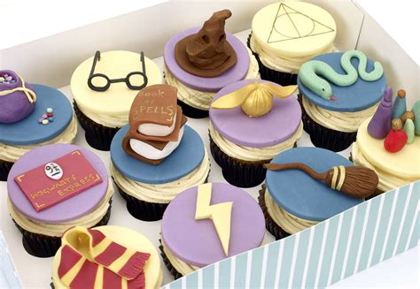 a box filled with lots of cupcakes decorated like harry potter and hogwarts