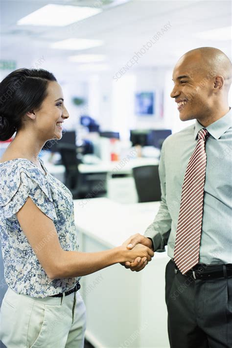 Business people shaking hands in office - Stock Image - F014/3090 - Science Photo Library