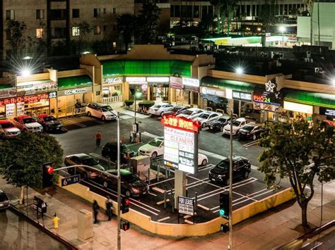 an overhead view of a city street at night with cars parked in the lot ...