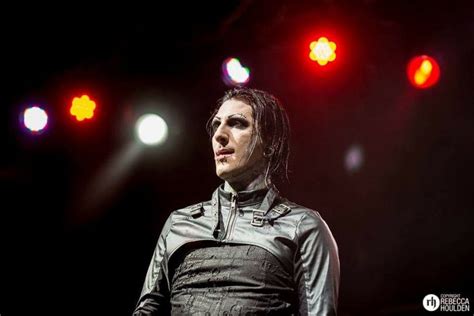 a man with dreadlocks standing in front of red and green lights on stage