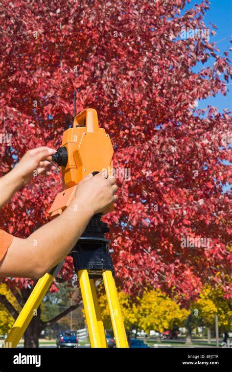 Hands on theodolite - land surveying during fall time Stock Photo - Alamy