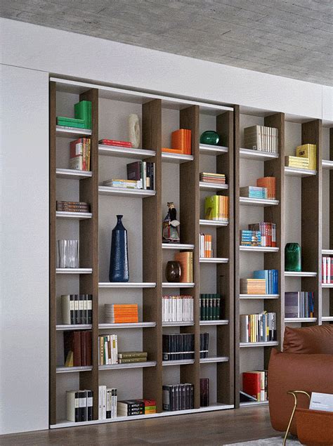 a living room filled with lots of bookshelves next to a brown leather couch