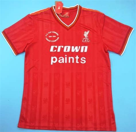 an old liverpool football shirt with the name crown paints on it's left ...