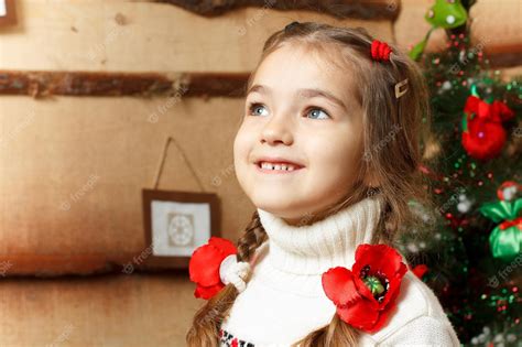 Retrato de la niña que sonríe niña con abeto | Foto Premium