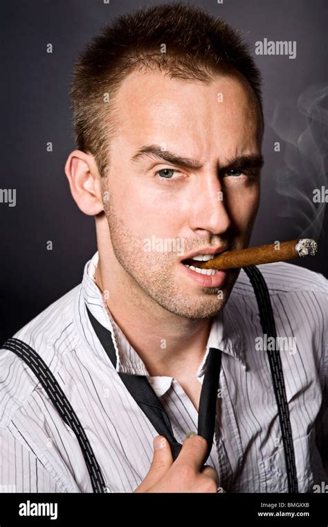 young handsome man smoking cigar Stock Photo - Alamy