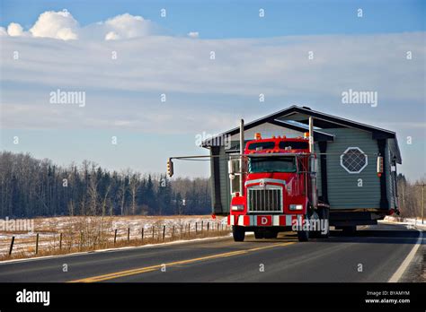 A tractor trailer truck moving a house Stock Photo - Alamy