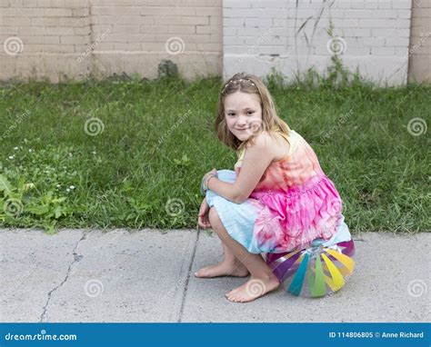 Beautiful Smiling Little Girl In Summer Dress And Bare Feet Sitting On ...