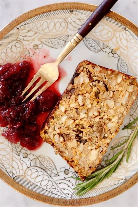 a white plate topped with fruit and bread next to a fork on top of a table