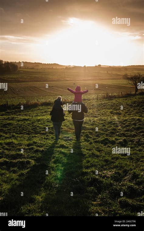 A family walking together at sunset Stock Photo - Alamy