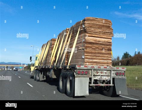 Flatbed trailer hauling lumber freight under blue sky Stock Photo - Alamy