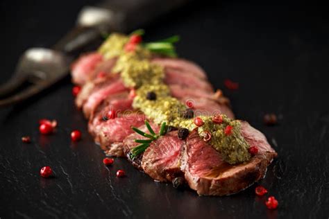 Medium Rare Venison Steak with Green Pesto Sauce and Pepper Stock Image - Image of board ...