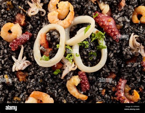 Top down close up of arroz negro seafood dish, garnished with squid and ...