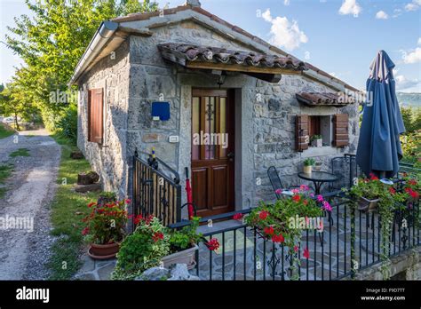 a small stone house with a metal fence Stock Photo - Alamy