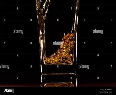 Close up of pouring fresh apple juice into glass. Black background ...