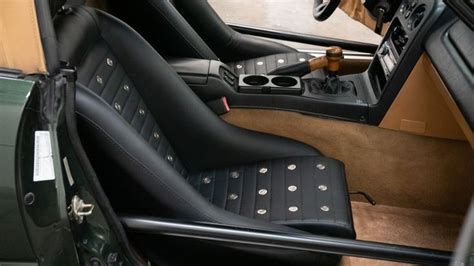 the interior of a car with black leather and tan flooring, including an automatic steering wheel