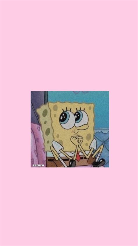 spongebob sitting on top of a bed in front of a pink wall