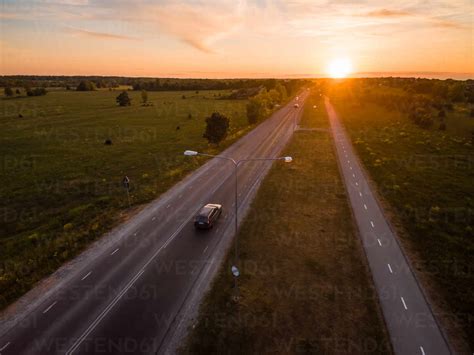 Aerial view of a car driving on a road at sunset in countryside. stock ...