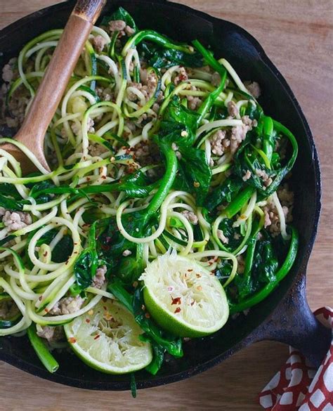a skillet filled with zucchini noodles and spinach