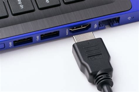 Premium Photo | Hdmi cable near the hdmi port of the modern blue laptop