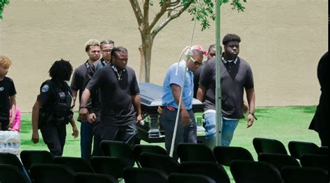 photo of x's friends, and family carrying his casket for open viewing ...