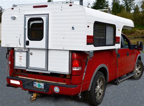 a red and white truck with a camper attached to it's back end