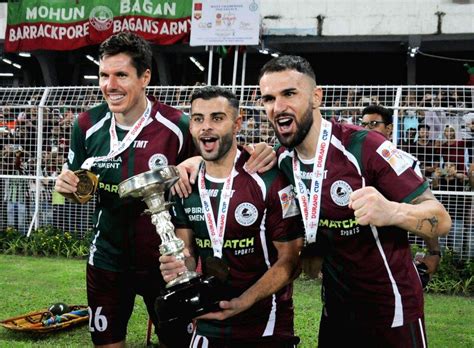 Mohun Bagan Super Giant players pose for photos with the trophy after ...