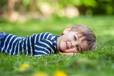 Smiling Little Boy Lying on the Grass in the Park Stock Photo - Image of life, beautiful: 54037322