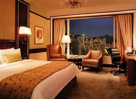 a hotel room with a view of the city lights and skyscrapers in the distance