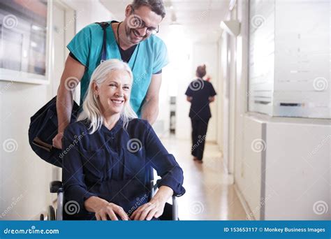 Male Orderly Pushing Senior Female Patient Being Discharged from Hospital in Wheelchair Stock ...