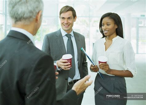 Business people talking in office building — meeting, Mid Adult - Stock Photo | #199733258