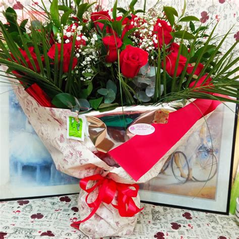 Ramo de 24 rosas rojas acompañadas de distintos tipos hojas verdes, para regalar en San Valentín.