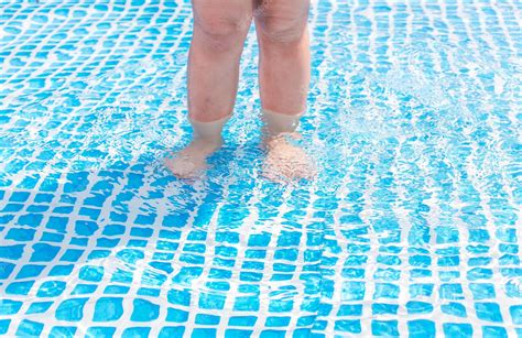 Premium Photo | A little girl is playing in an inflatable pool at home ...