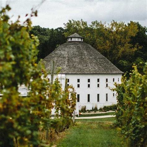 White circular tasting building surrounded by vineyards at Round Barn Winery, Distillery ...