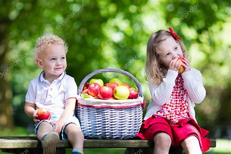 Kids eating apple in the garden — Stock Photo © FamVeldman #117323792