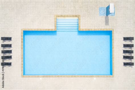 Aerial view of empty swimming pool with shower outdoors. Beautiful pool with clear water as ...