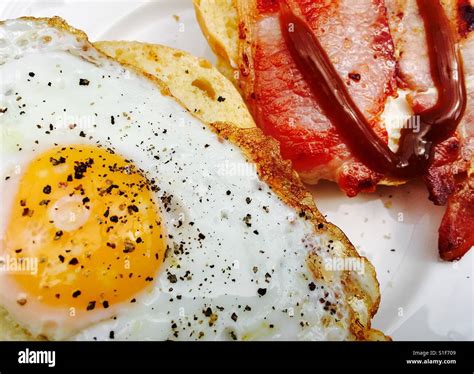 Fried egg and bacon roll with brown sauce Stock Photo - Alamy