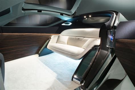 the interior of an electric vehicle with wood and white leather seats ...