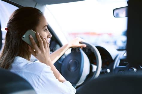 Brunette Woman Talking on a Cell Phone while Driving a Car. Stock Photo ...