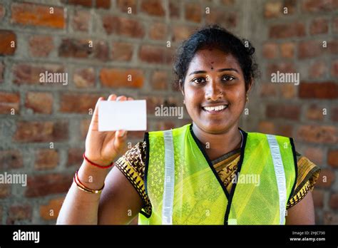 Indian happy smiling labour women showing empty card by lookig at camera - concept of empoyee id ...