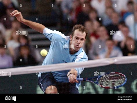 Greg Rusedski plays a fine low volley to win a point from Thomas ...