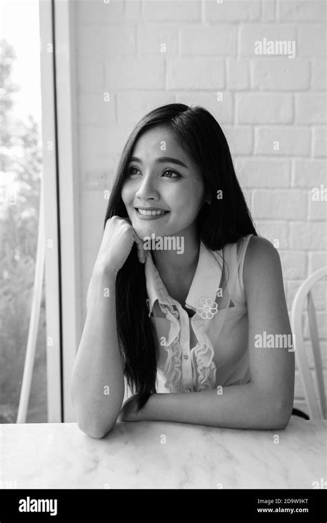 Young beautiful Asian woman thinking at coffee shop Stock Photo - Alamy